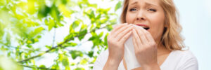 A woman sneezing and suffering from springtime allergies