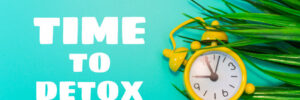 Alarm clock on grass background. inscription - time to detox.