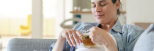 Pregnant woman relaxing in sofa drinking hot herbal tea