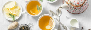 Green tea with lemon, ginger, sage on a light background, top view. Healthy detox drink. Tea ceremony