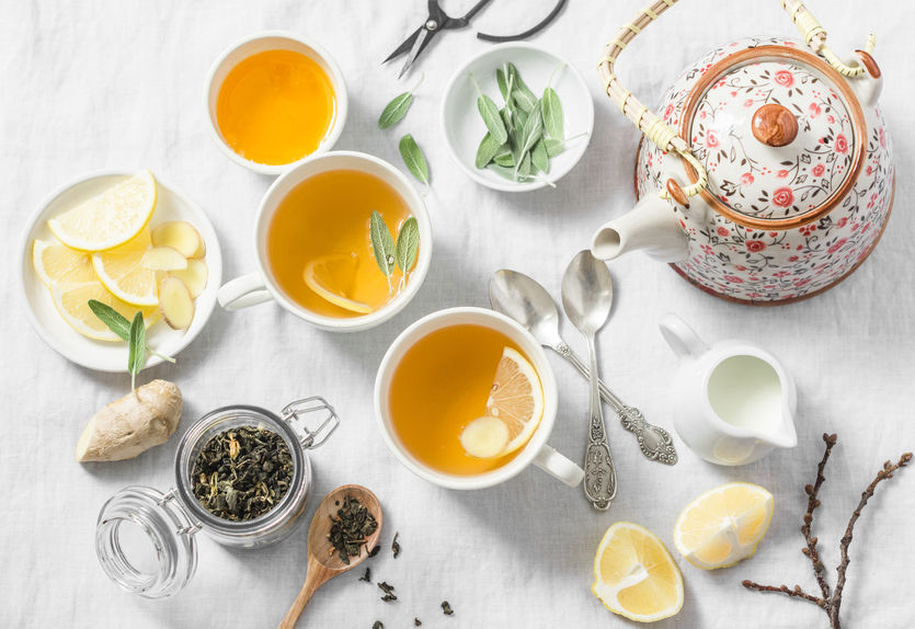 Green tea with lemon, ginger, sage on a light background, top view. Healthy detox drink. Tea ceremony
