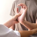 Kinesiology treatment concept. Muscle-testing service on female patients arm.