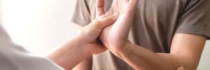 Kinesiology treatment concept. Muscle-testing service on female patients arm.