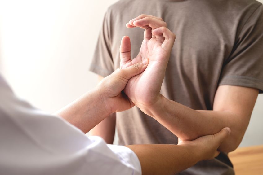 Kinesiology treatment concept. Muscle-testing service on female patients arm.